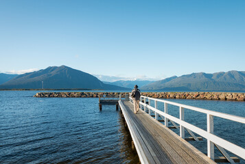 Man walking on the jetty and enjoying the views at Lake Brunner, South Island