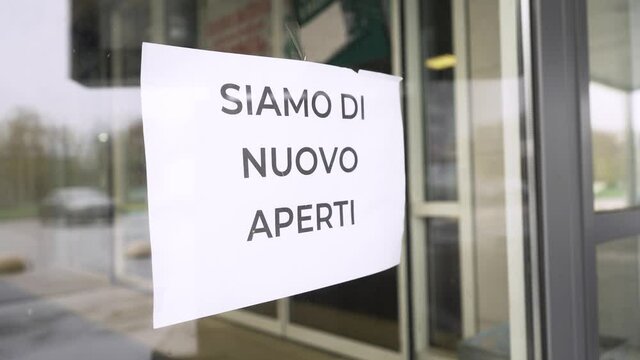 The sign "Natale annullato a causa di covid-19" hangs on restaurant glass door during pandemic covid-19 coronavirus quarantine. Business is opening after lockdown.