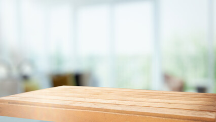 The top of the wooden table on the blur of the windowpane. Green color from a vegetable garden on the morning background. For product montage display.