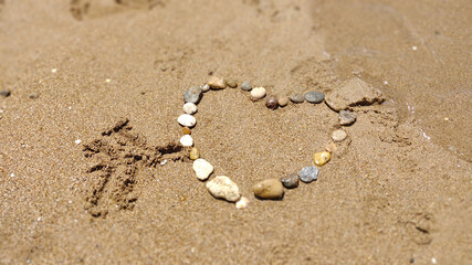 symbol of the heart drawing stones on the sand