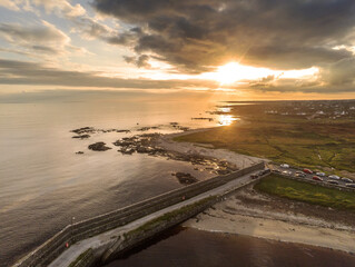 Aerial drone view on a Spiddal stone pier. County Galway, Ireland. Atlantic ocean, Sunset time. Dramatic sky.