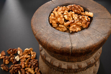Walnuts in antique, wooden mortar.