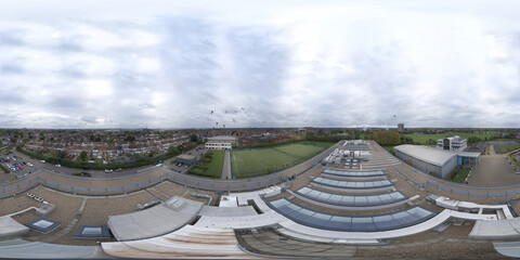 An aerial 360 Degree full sphere panoramic photo of an old school building across the town of Dagenham in the UK