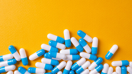 white and blue pills on yellow background