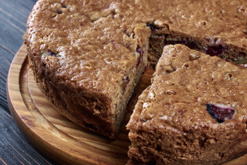 Chocolate charlotte pie on a wooden tray with a cut piece, close-up