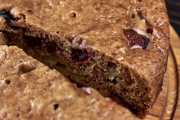 Chocolate charlotte pie on a wooden tray with a cut piece, close-up