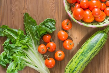 fresh organic vegetables on a wooden table. tomatoes, zucchini, chard.
