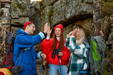 enthusiastic happy tourists on mountains or rocks together, sportive people explore the forest and nature, environment, hikinh trekking concept