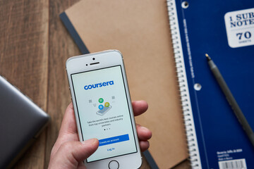 Portland, OR, USA - Apr 3, 2020: A man using the Coursera mobile app from his smartphone. Coursera is an online learning platform that offers massive open online courses, specializations, and degrees.