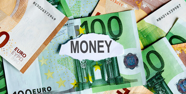 Focus on the word MONEY on piece of torn white paper with EUROS currency as a background.