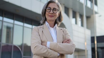 Self confident senior woman in elegant business suit posing at camera, success