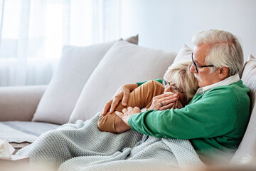 I got flu. Pretty old woman is looking at thermometer while sitting covered with blanket near her husband. Through sickness, health and everything in between.