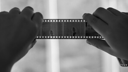 A woman holds a negative from an old film camera.