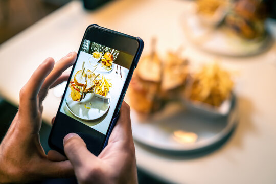 Food photography blogger influencer taking picture with her smartphone. Close up on the cell phone screen.