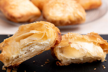 white cheese puff pastry on a black plate and a white plate