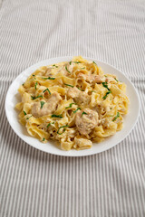 Homemade Chicken Fettuccine Alfredo on a white plate, low angle view.