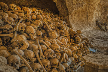 Spooky detail of a pile of skulls and bones in a crypt bears death and life value concept and...