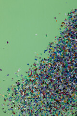 Recycled plastic soup pellets collected from the sea water, flatlay on a green background. Colorful...