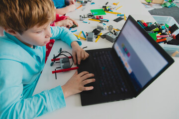 kids building robot and programming it on computer