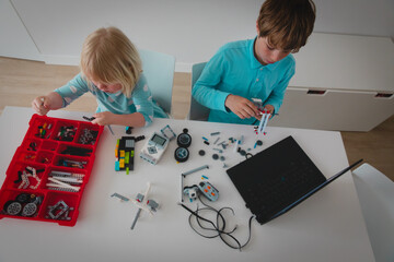 little girl and boy building robots from colorful plastic blocks