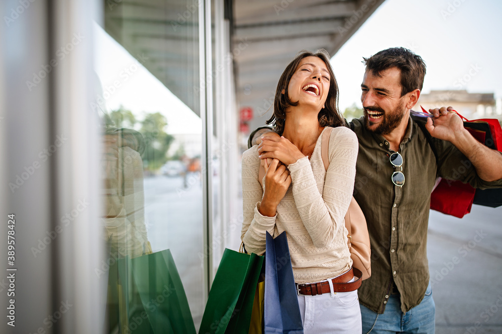 Wall mural beautiful young loving couple walking by the street while shopping and traveling