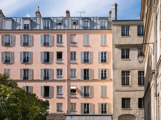 Architecture in Paris, Blue sky and white clouds, roof and attic room, low-angle shot, historic front buildings windows, artistic view of the city center