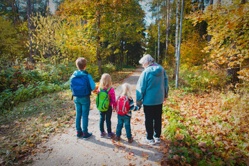 grandmother with kids walk in autumn nature
