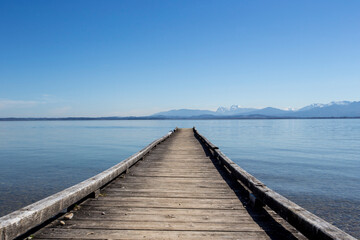 Fototapeta premium travel germany and bavaria, view above a lake with landing stage and mountain view, Chiemsee, Bavaria, Germany