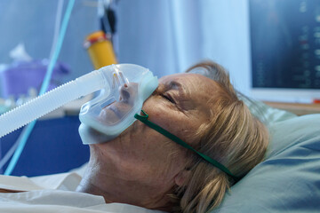 Close-up of covid-19 patient in bed in hospital, coronavirus and ventilation concept.