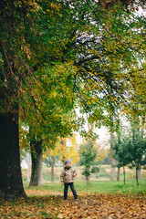 Fototapeta premium child playing in the autumn forest