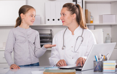Little girl talking with doctor about sick of throat in the doctor's office