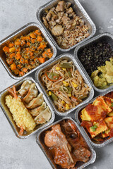Different aluminium lunch box with with takeout coronavirus food.  Food delivery covid-19 takeaway 