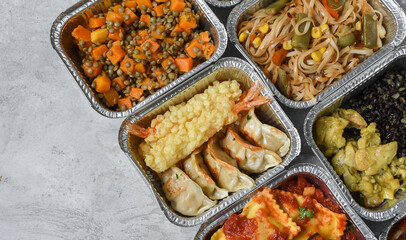 Different aluminium lunch box with with takeout coronavirus food.  Food delivery covid-19 takeaway 