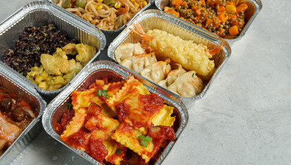 Different aluminium lunch box with with takeout coronavirus food.  Food delivery covid-19 takeaway 