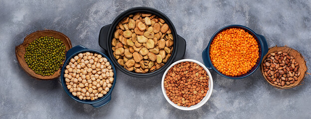 Various assortment of legumes beans, chickpeas, lentils, green peas. Healthy eating concept. Vegetable proteins. concrete background copy space top view 