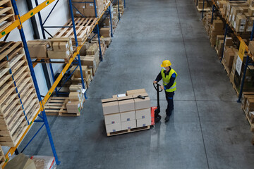 High-angle view of man worker working indoors in warehouse, coronavirus concept.