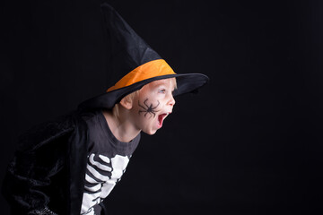 Child, dressed for Halloween, playing at home, isolated image on black