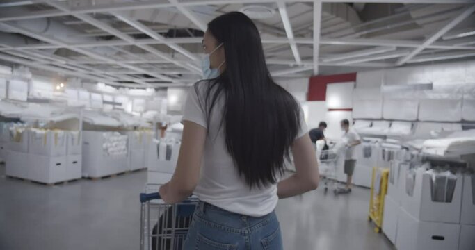 Close up women using shopping cart  in shopping mall.Shot of the view from the back of the model