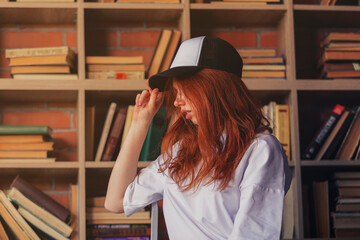 Portrait of a redhead woman in template blank t-shirt and cap with healthy freckled skin. Young...