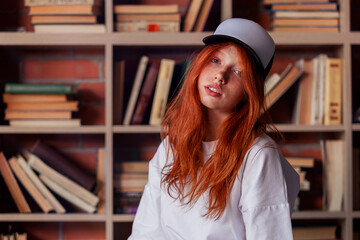 Portrait of a redhead woman in template blank t-shirt and cap with healthy freckled skin. Young...