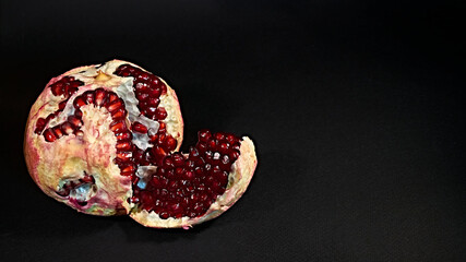 Closeup view of grain red grenades. Juicy ripe red pomegranates or pomegranates. Fruits of red ripe pomegranate on a studio background. Vegetarian concept, organic vitamins. low light