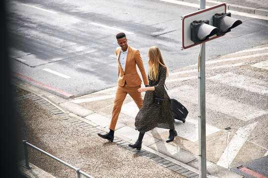 High Angle View Of Business Couple Crossing Street On Way To Meeting - Powered by Adobe
