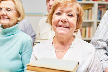 Smiling senior woman borrowing books