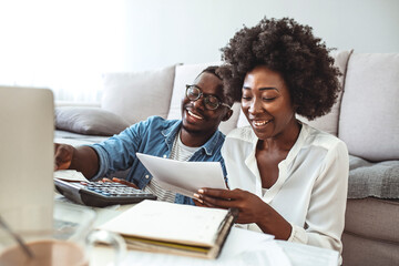 Family insurance concept. Positive black couple reading documentation at home, checking agreement...