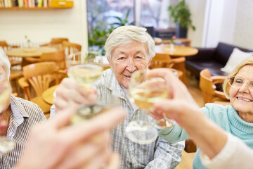 Seniors toast with a glass of white wine