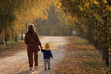 Fototapeta premium mother and child walking in autumn park