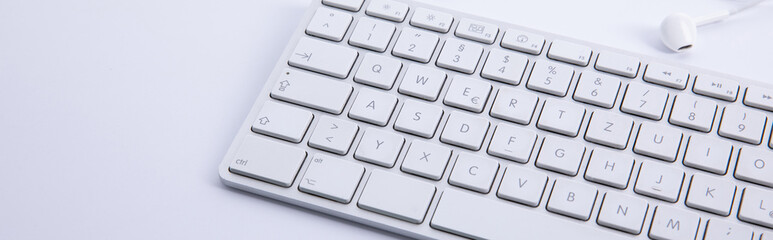 new modern keyboard with snew modern keyboard with smartphone and earphones isolated on white background, close view martphone and earphones isolated on white background, close view . High quality