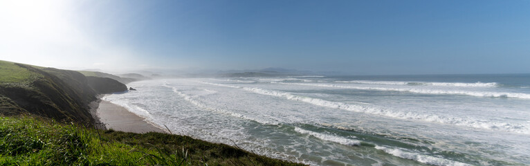 green grassy cliffs drop down to the ocean coast in northern Spain