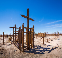 dilapidated graves in the cemetery of a ghost town from the nitrate time in the Atacama desert
