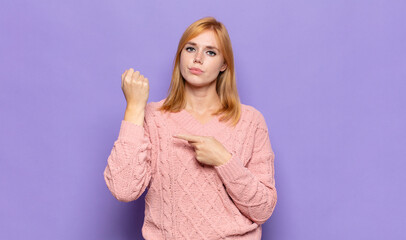 red head pretty woman looking impatient and angry, pointing at watch, asking for punctuality, wants...
